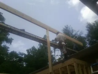 Carpenter setting a ridge beam over a new addition frame — Ice Dam Removal by Roofing Brothers in Belvidere