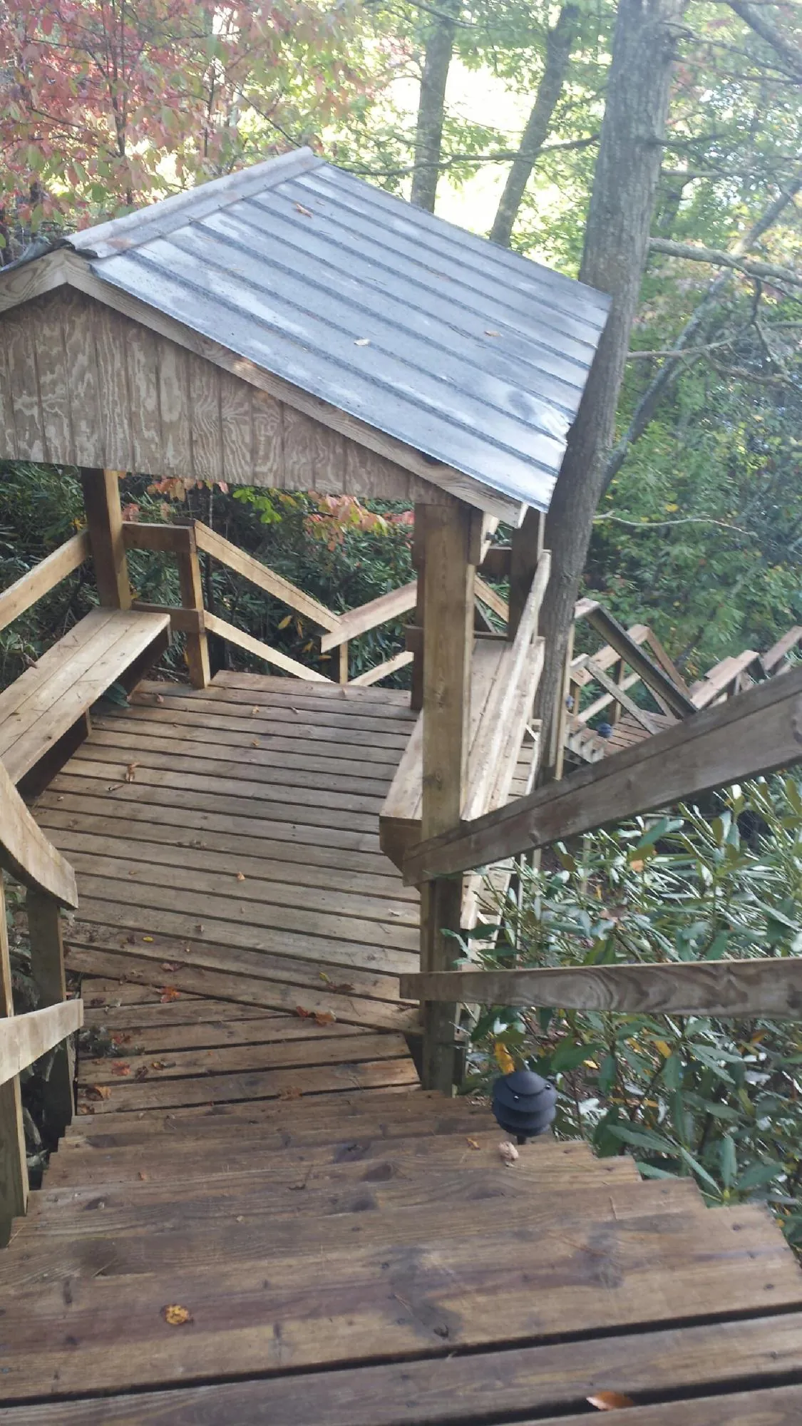 Metal roofed shelter over wooden steps on a wooded walkway — Skylight Repair & Installation work by our crew in Belvidere